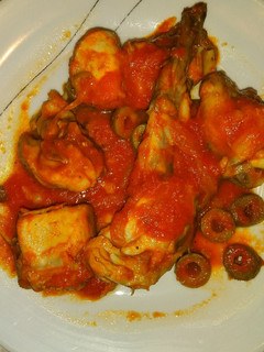 Una foto de Conejo con salsa de tomate y aceitunas