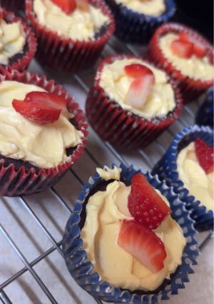 A picture of Chocolate Cupcakes with Vanilla Icing and Strawberries.