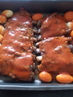 Una foto de Costillar al horno con salsa barbacoa casera y papas cocidas
