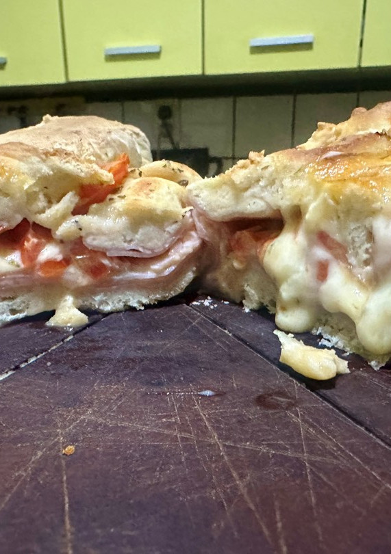 Una foto de Stromboli de jamón, queso y tomate