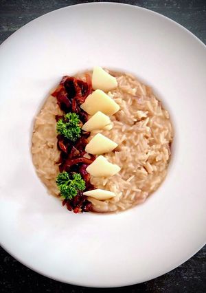 A picture of Risotto with Caramelized Red Onions and Grana Cheese Shavings.