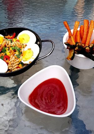 A picture of Veg Pasta with Egg and flavoured bacon bits carrot chips + Dip.