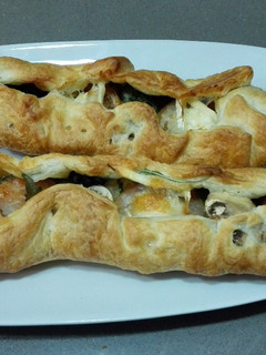 Una foto de Hojaldre relleno con queso de cabra, rúcula, tomate y champiñones