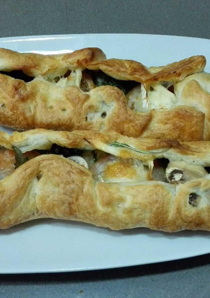 Una foto de Hojaldre relleno con queso de cabra, rúcula, tomate y champiñones 