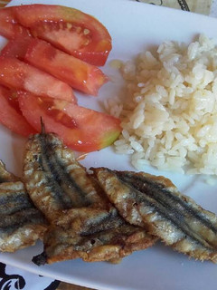 Una foto de Boquerones fritos con arroz y tomate fresco