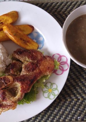 Una foto de Chuleta al sartén, en cama de lechuga crepa y lentejas