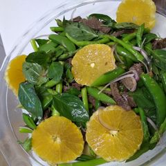 A picture of Beef salad with orange dressing.