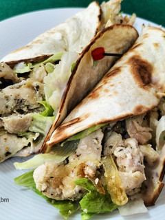 Una foto de Fajitas de pollo con lechuga, cebolla y salsa de queso y nueces