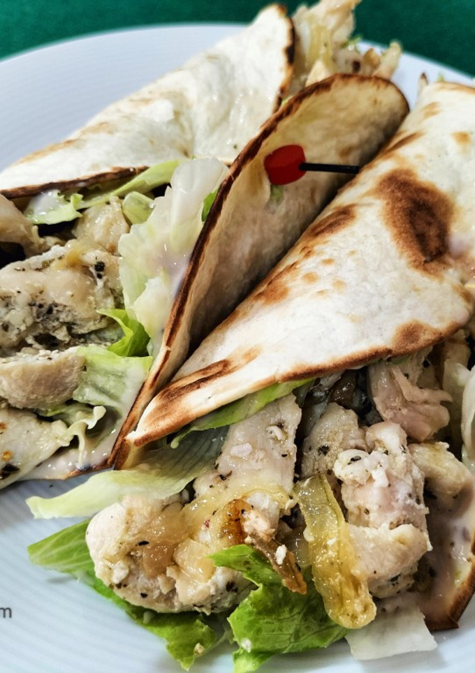 Una foto de Fajitas de pollo con lechuga, cebolla y salsa de queso y nueces