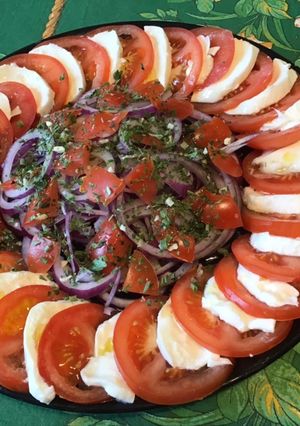 Une photo de Salade de tomates à l oignon rouge et mozzarella di buffala