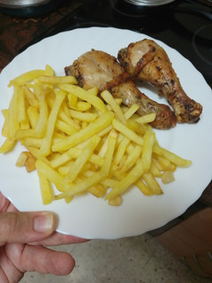 Una foto de Muslos de pollo asados en freidora de aire con papas fritas