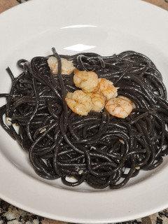 Una foto de Espaguetis nero di sepia con gambas al ajillo