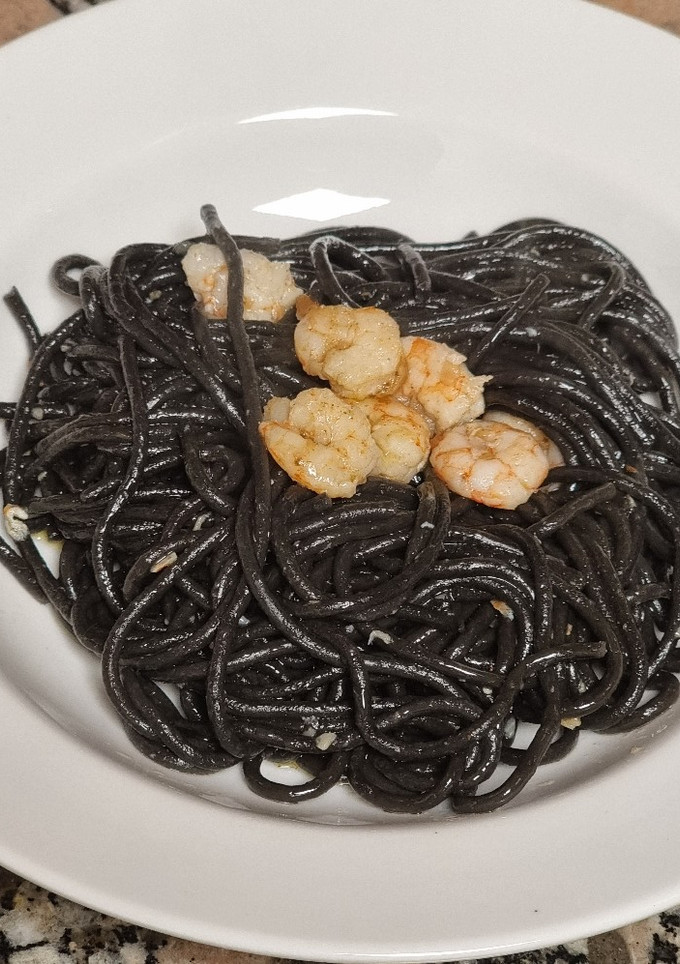 Una foto de Espaguetis nero di sepia con gambas al ajillo