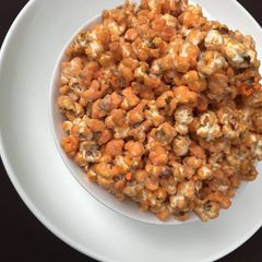 A picture of Orange popcorn coated with milk.