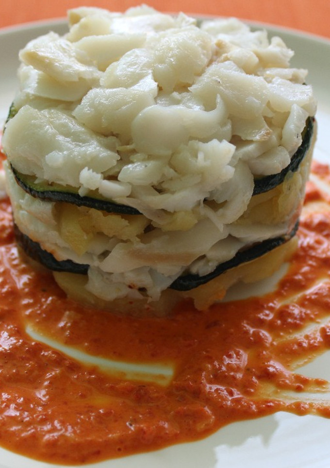 Una foto de Timbal de bacalao confitado sobre salsa de pimientos de piquillos