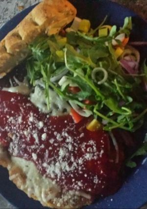 A picture of Chicken parm w/leek arugula salad.
