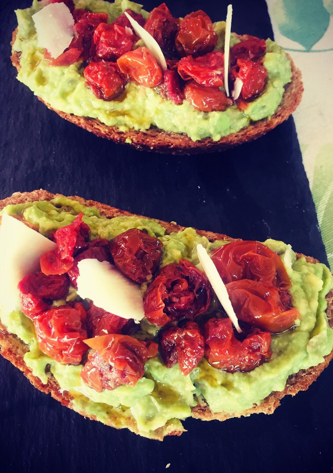 Una foto de Tosta de aguacate y cherrys confitados con lascas de parmesano