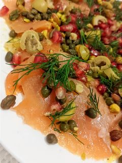 Una foto de Carpaccio de salmón ahumado sobre cama de hinojo asado
