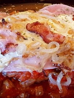 Una foto de Milanesa a la napolitana con cebollas caramelizadas