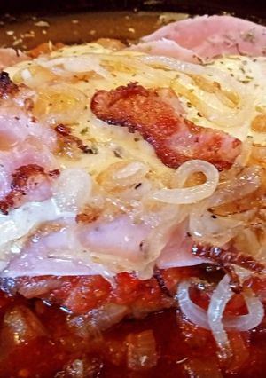 Una foto de Milanesa a la napolitana con cebollas caramelizadas