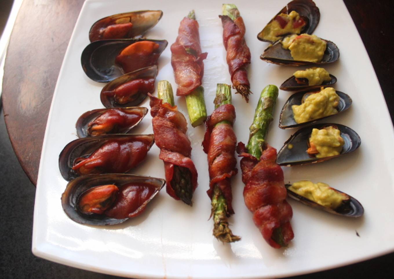 Mejillones cocidos con espárragos envueltos en bacon