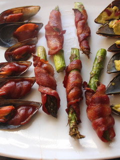 Una foto de Mejillones cocidos con espárragos envueltos en bacon