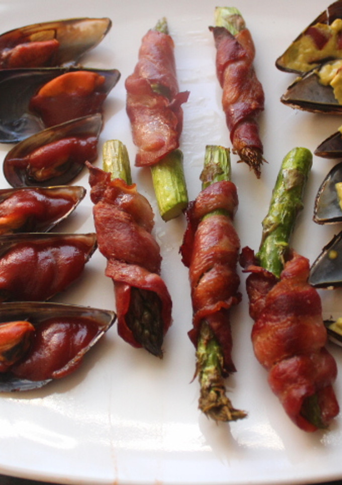 Una foto de Mejillones cocidos con espárragos envueltos en bacon