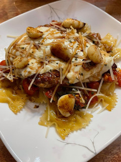 A picture of Bruschetta Caprese Chicken over Bowtie Pasta.