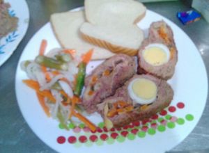 Una foto de Rollo de carne y en salada de zanahoria con habichuela y cebolla blanca
