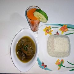 A picture of Boiled rice with goat meat peppersoup and watermelon juice.