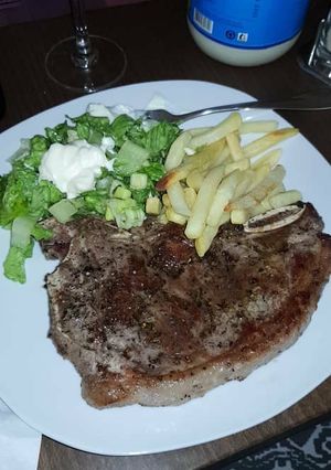 A picture of Grilled meat with chips and lettuce.
