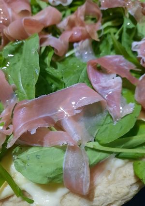 Una foto de Pizza casera con rúcula y jamón crudo