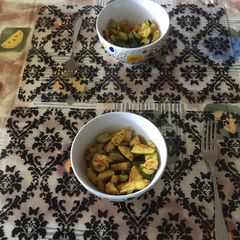A picture of Curry chicken breasts with zucchini/courgette.