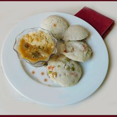A picture of Idli with oats and veggies, sambar.