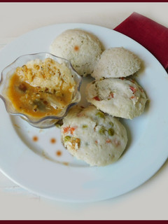 A picture of Idli with oats and veggies, sambar.