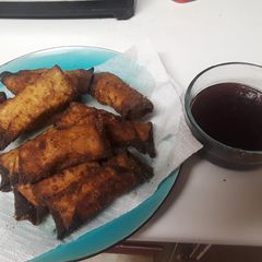 A picture of Thanksgiving leftover egg rolls with cranberry sweet & sour sauce.