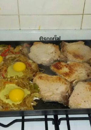 Una foto de Costeletas de cerdo y colchón de verduras y huevo a la plancheta