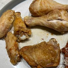 A picture of Chicken wings, drumsticks and thighs in air fryer.