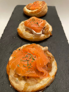 Una foto de Hojaldres con salmón, queso y cebolla caramelizada
