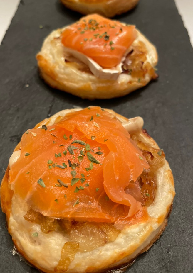 Una foto de Hojaldres con salmón, queso y cebolla caramelizada