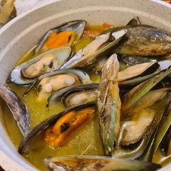 A picture of Mussels in white wine sauce.
