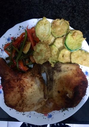 Una foto de Chuletas de cerdo empanadas con piperrada y calabacín rebozado