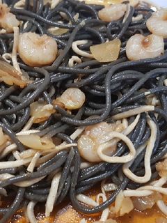 Una foto de Spaguetti al Nero di Seppia con gulas y gambas