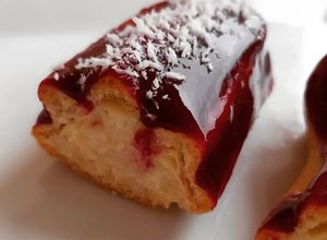 Foto principal de Eclair de crema de almendras y cobertura coulis de frutos rojos y coco