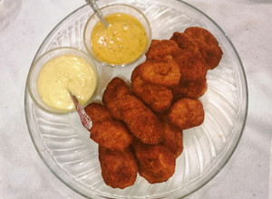 Una foto de Nuggets de pollo acompañado con mayonesa y aderezo de chipotle