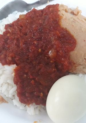 A picture of Rice,moimoi and pepper sauce.