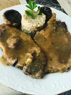 Foto principal de Chuletas de aguja en salsa con guarnición de champiñón al horno y arroz hervido con trufa rallada