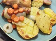 Una foto de pollo asado con patata y zanahoria