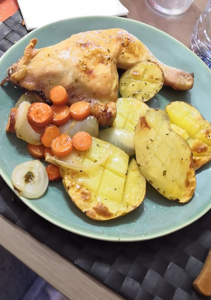 Una foto de Pollo asado con zanahorias, cebollas y patatas asadas
