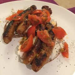 A picture of Hungry dinner: bread, sausage, ricotta, tomatoes.
